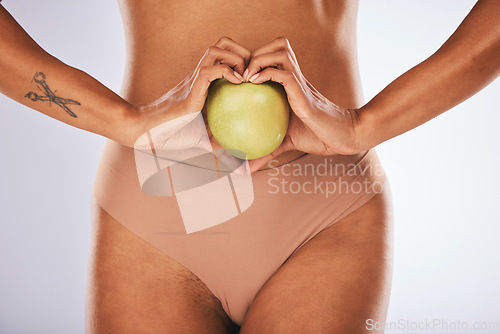 Image of Health, heart shape and woman with a apple for a healthy, nutrition and organic diet snack. Fitness, wellness and slim female body with love hand gesture for fruit for weightloss by studio background