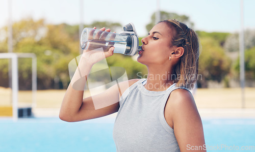 Image of Water, thirsty and woman with a bottle after running, training hydration and energy on a court. Fitness, sports and athlete with a drink break after a workout, exercise and tired of sport in Germany