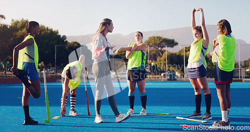 Image of Hockey, women team with coach and sport outdoor, coaching and game strategy, training and fitness on turf. Athlete stretching, start practice and wellness with match plan, motivation and support