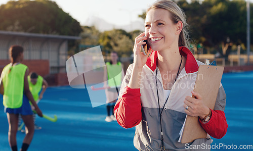 Image of Hockey, trainer and phone call by woman at a stadium for training, workout and fitness while talking during a match. Sports, coach and female happy, smile and excited while enjoying conversation