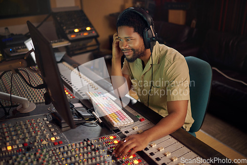 Image of Computer, music and male producer in studio working on a album, song or audio with tech equipment. Happy, smile and black man radio presenter playing a playlist with technology in creative workplace.