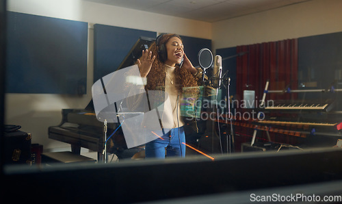 Image of Headphones, singing or musician with studio microphone in album recording, evening audio or radio music at night. Singer, woman or artist in production song, voice media or sound performance practice