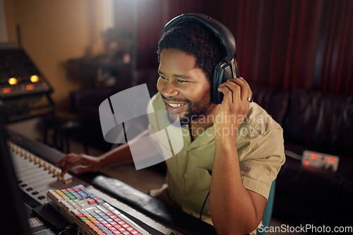 Image of Headphones, recording studio and man music producer working a album, song or audio with equipment. Happy, smile and African male radio presenter playing playlist with technology in creative workplace