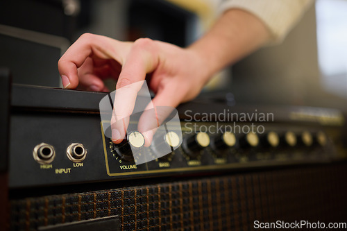 Image of Hands, amplifier volume and music studio with female musician or producer with equipment. Technology, audio and hand of woman adjusting sound nob on dj machine or radio amp in creative workplace.