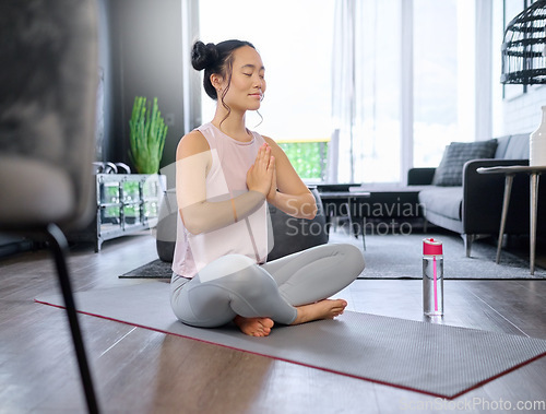 Image of Prayer hands, yoga and meditation of Asian woman in home living room for mindfulness exercise. Zen chakra, pilates and female yogi training and meditating with namaste hand pose for relax and peace.