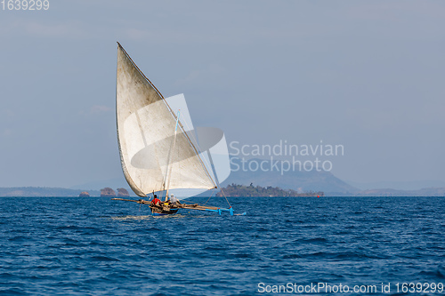 Image of Malagasy fisher on sea in traditional handmade dugout wooden sailing boat