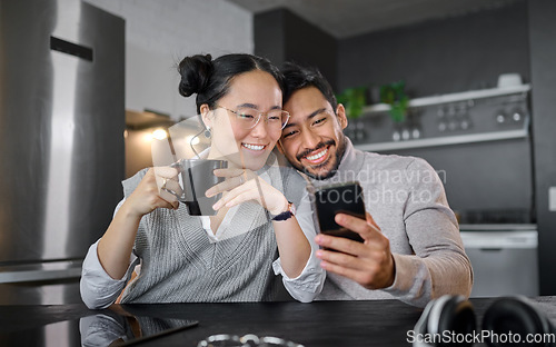 Image of Love, coffee and couple with phone in home kitchen watching video online. Social media, tea and diversity of man and woman with mobile smartphone streaming movie or film and bonding at night in house