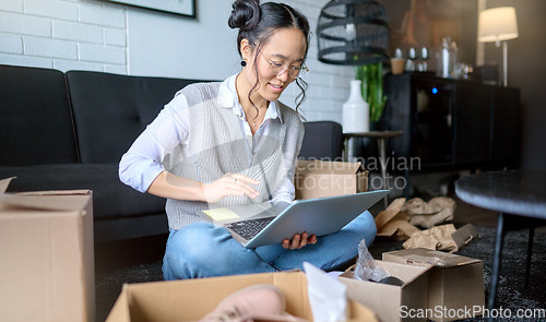 Image of Real estate, laptop and Asian woman moving into new home while planning or calculating mortgage online. Relocation boxes, computer and female property owner or remote worker in living room of house.