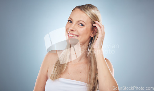 Image of Portrait, beauty and hair with a model woman in studio on a gray background for skincare treatment. Face, skin and natural with an attractive young female posing to promote antiaging cosmetics