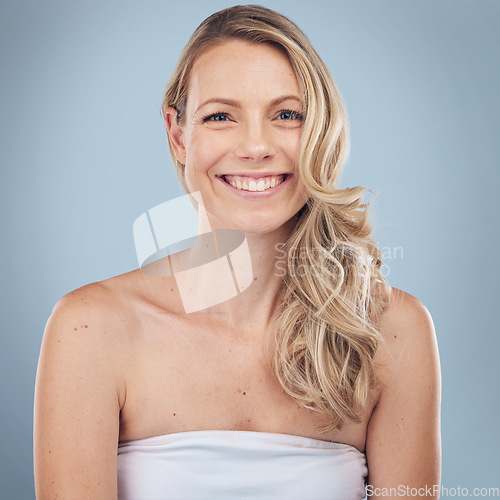 Image of Portrait, skincare and happy with a model woman in studio on a gray background for natural treatment. Face, beauty and smile with an attractive young female posing to promote a cosmetic product