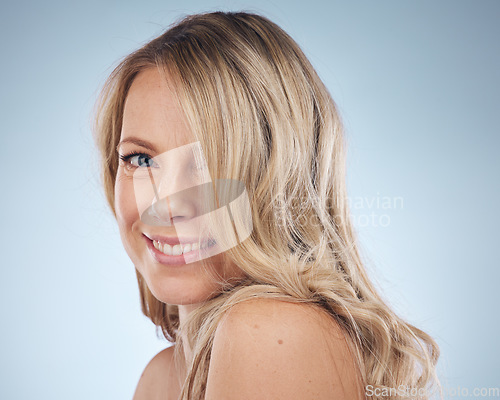 Image of Portrait, hair and happy with a model woman in studio on a gray background for keratin treatment. Face, haircare and smile with an attractive young female posing to promote natural beauty or skincare