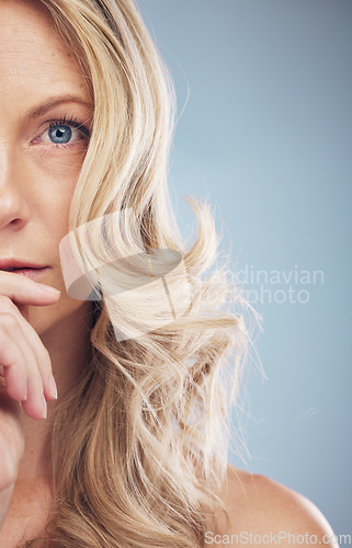 Image of Half face, hair care and beauty of woman in studio isolated on a blue background. Makeup cosmetics, portrait or female model with beautiful curly hairstyle after salon treatment for growth or texture