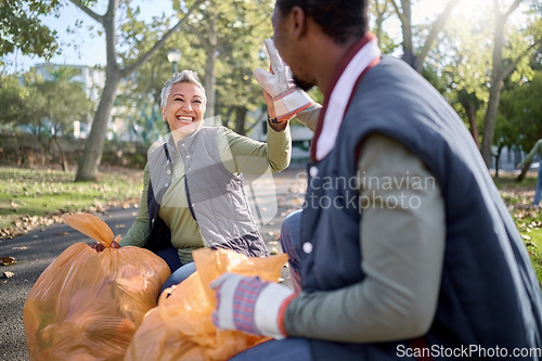 Image of Volunteer, community service and team high five for cleaning park with bag for a clean environment. Happy man and woman helping with trash or garbage for eco friendly recycling outdoor in nature