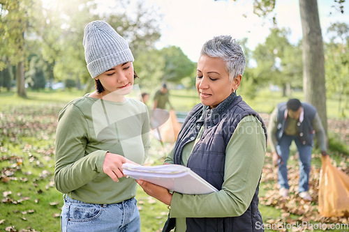 Image of Volunteer schedule, community cleaning and charity work outdoor with women planning a project. Recycle team, collaboration and eco friendly job with people checking volunteering data in a park