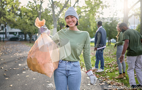 Image of Plastic bag, park and happy woman in cleaning portrait for earth day, community service or volunteering support. Recycle, trash or garbage goals of ngo person helping in nature or forest pollution