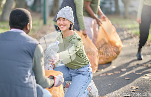 Image of Volunteer, community service and people cleaning plastic in park with garbage bag. Happy woman and man team help with trash for eco friendly lifestyle and recycling in nature for a clean enviroment