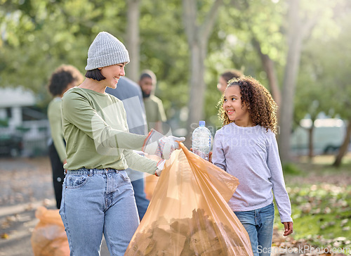 Image of Volunteer, child and woman cleaning plastic in park with garbage bag for a clean environment. People learning and helping with trash for eco friendly, community service and recycling bottle in nature