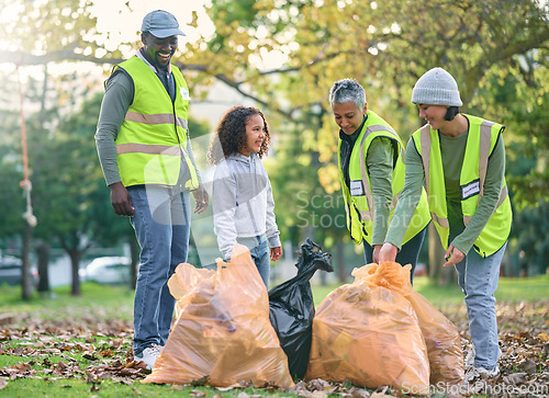 Image of Child with volunteer group for cleaning park with garbage bag for a clean environment. Men, women and child team helping and learning eco friendly lifestyle, community service and recycling in nature