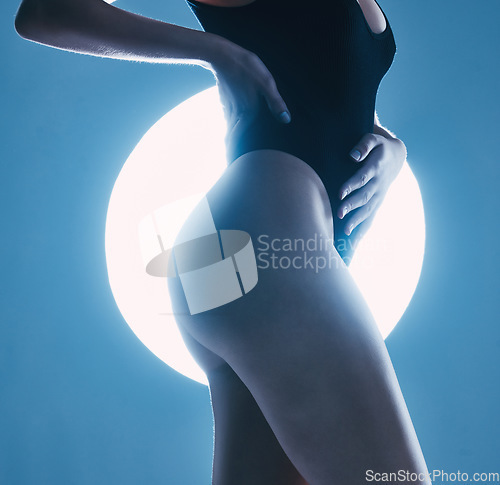 Image of Sexy, legs and body of a woman with a spotlight isolated on a dark background in a studio. Fashion, curves and butt of a model posing for sensuality, seductive and erotic energy on a backdrop