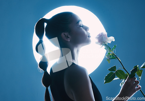 Image of Circle light, art and woman in studio on blue background with flower for dark beauty aesthetic, magic and fantasy. Night, futuristic or creative model person with white rose on moon spotlight mockup