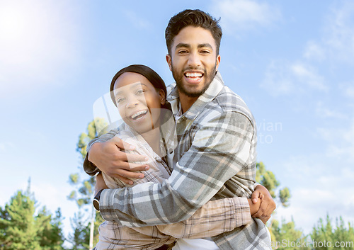 Image of Portrait, couple of friends and hug while hiking in nature, forest and park. Diversity, man and woman embrace outdoors for journey, travel and adventure together on blue sky with love, smile or care