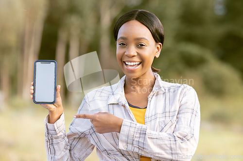 Image of Mockup phone screen, smile and portrait black woman pointing at marketing or advertising content. Outdoor, technology and person point with happiness and online on mobile with blurred background