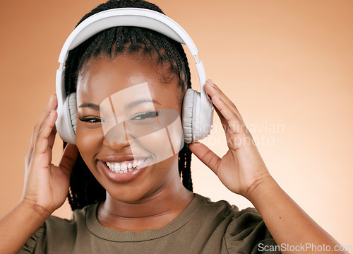 Image of Headphones, face and music black woman isolated on studio background for gen z streaming, radio and smile. Happy portrait, person listening to audio for beauty podcast, youth confidence and mockup