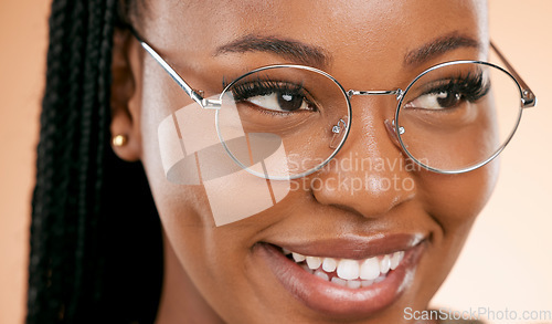 Image of Black woman, face zoom and smile with glasses, vision and prescription lens isolated on studio background. Eyewear, eye care and healthcare for eyes, happy girl with fashion frame and optometry