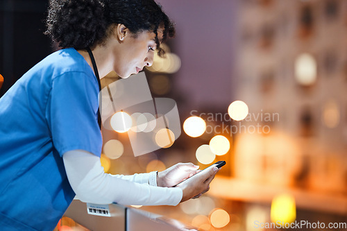 Image of Night, doctor and woman texting in city while on a break, internet and search against a bokeh background. Nurse, female and online app for schedule, calendar and planner while relaxing on a balcony