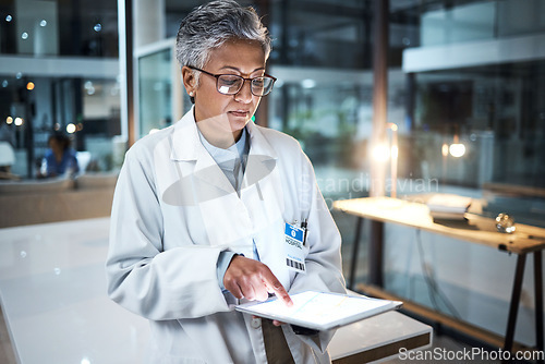 Image of Doctor, tablet and senior woman in hospital working on telehealth, research or online consultation. Medical, healthcare or elderly female physician with technology for wellness app in clinic at night