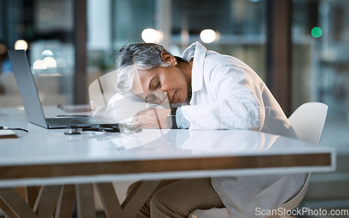 Image of Woman doctor sleeping at desk in overtime medical office, late hospital and burnout. Stress, night and healthcare worker nap at table with fatigue, tired job and mental health problem from overworked