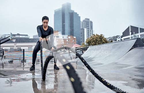 Image of Fitness, workout and black woman with rope in city for cardio exercise, bodybuilder training and sports. Wellness, motivation and female athlete focus with gear for strong muscles, power and energy