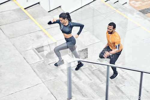 Image of Fitness, above and running couple on stairs for training, health exercise and sports in city. Healthy, lifestyle and man and woman with focus, music and energy for outdoor cardio on steps in France