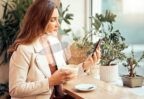 Image of Coffee shop, phone and communication with a woman customer drinking while typing a text message by a window. Internet cafe, mobile and social media with a female enjoying a drink in a restaurant