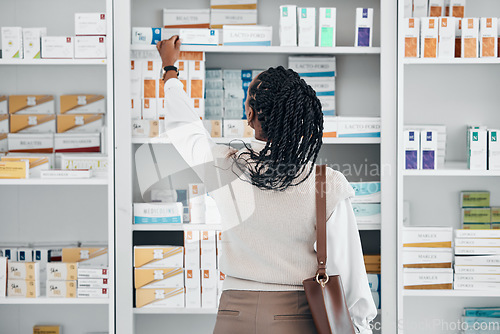 Image of Pharmacy, black woman and pills stock of a customer shopping for medicine, wellness cream or product. Female back, shop and drugs clinic with a person looking for health, medical and shelf products