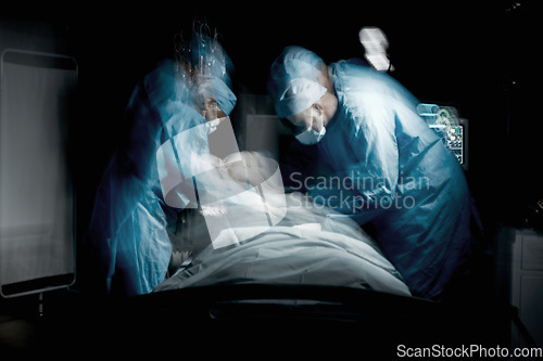 Image of Healthcare, surgery and team of surgeons working on a patient for an emergency operation in the hospital. Medical, blur motion and group of doctors operating in a surgical room in the medicare clinic