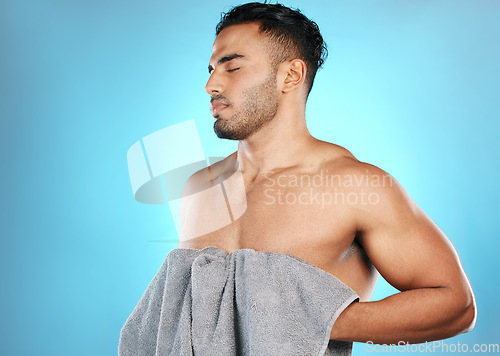 Image of Skincare, man and clean with towel, cosmetics and wellness for body care on blue studio background. Male, gentleman and cloth for drying, natural beauty and hygiene grooming routine and treatment