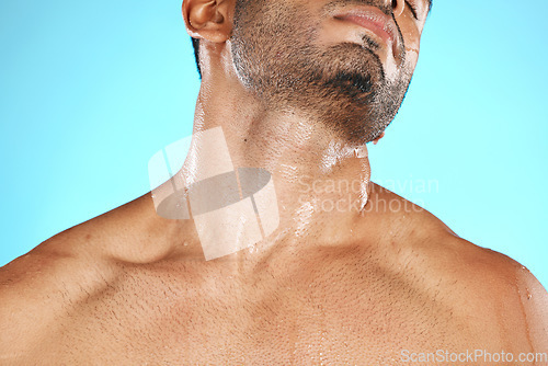 Image of Skincare, neck and man with cosmetics for wellness, health and washing on blue studio background. Male, gentleman and wet shoulders for natural beauty, hygiene and cleaning for smooth and soft skin