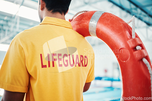 Image of Lifeguard, man and swimming pool safety at indoor facility for training, swim and exercise. Pool, attendant and water sports worker watching for danger, protection or diving athletics, ready and safe