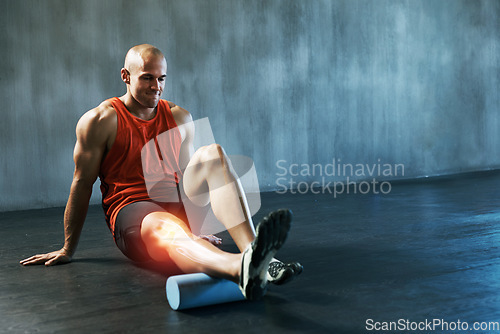 Image of Stretching, fitness and man with a foam roller for muscle relief, training and care for body at gym. Sports, warm up and athlete with inflammation in legs, equipment for physical therapy and injury