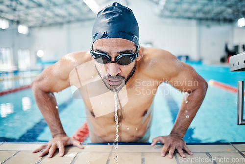 Image of Tired, breathing and man swimming for fitness, training and race in a stadium pool. Strong, sports and face of an athlete swimmer doing cardio in the water for a workout, sport and competition