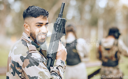 Image of Paintball gun, man and portrait with smile, camouflage clothes and excited to start military combat game. Army training, warfare games and adventure for workout, shooting and challenge with friends