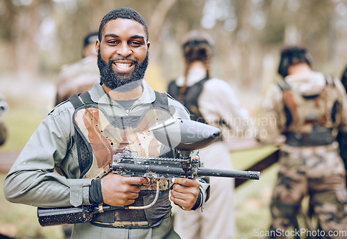 Image of Paintball, gun and portrait of black man with smile ready for game, match and shooting battle outdoors. Extreme sports, adventure and male in camouflage, military clothes and action gear for arena