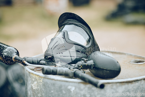 Image of Equipment, paintball and gun with helmet ready for competition, match or game outdoors in battlefield. Tools, safety gear and recreation weapon for fun or extreme sport and game outdoors