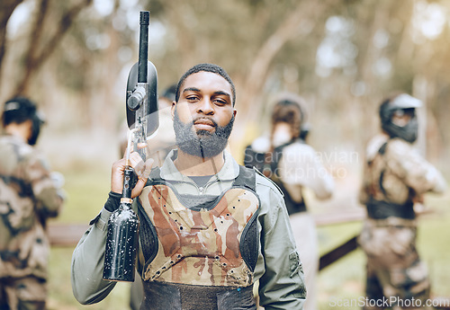 Image of Paintball, gun and portrait of black man in park ready for games, match and shooting battle outdoors. Extreme sports, adventure and male in camouflage, military clothes and action gear for arena