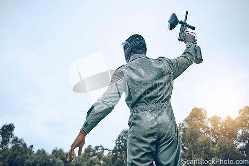 Image of Paintball gun, winner person and blue sky mockup for success in battlefield game, outdoor sports or adventure. Shooting, war and fitness man in safety gear for military training, action and winning