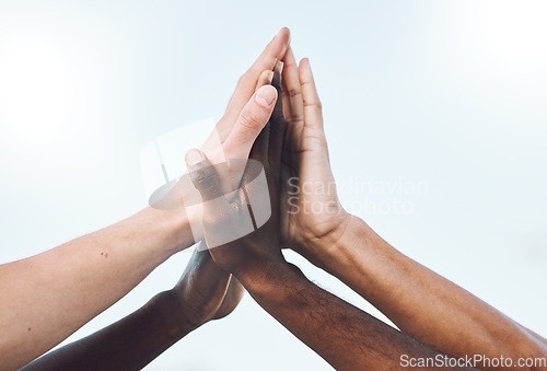 Image of Sports, teamwork and hands high five for support, motivation and community with blue sky background. Collaboration, team building and group of players ready for game success, training and celebration