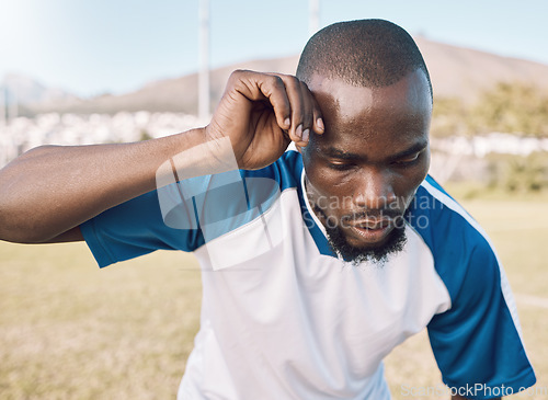 Image of Black man is tired, face and football player on outdoor field, playing game or soccer training with energy and exhausted athlete. Team sport, sweating and fitness, challenge and fatigue with workout