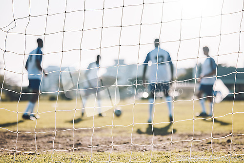 Image of Goal post, field and football players training for sports energy, workout or game on blurred background. Fitness, focus and power of soccer team or group of people on a pitch in park for challenge