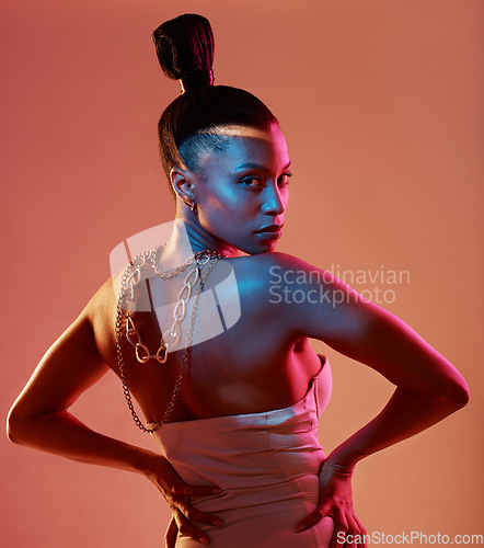 Image of Portrait, art and neon with a model black woman in studio posing in underwear on an orange background. Aesthetic, beauty and fashion with an attractive young female standing on a kaleidoscope wall